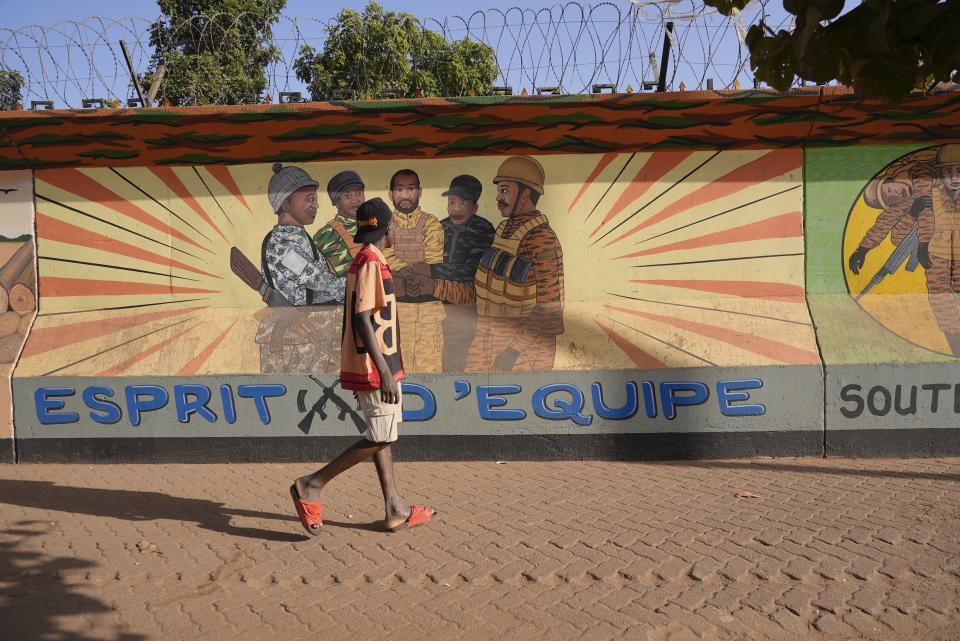 A man walks past a mural in Ouagadougou, Burkina Faso, Wednesday March 1, 2023. Burkina Faso has been wracked by violence linked to al-Qaida and the Islamic State group that has killed thousands, but some civilians say they are even more afraid of Burkina Faso’s security forces, whom they accuse of extrajudicial killings. The military junta has denied its security forces were involved, but a frame-by-frame analysis by The Associated Press of the 83-second video shows the killings happened inside a military base in the country’s north. (AP Photo)