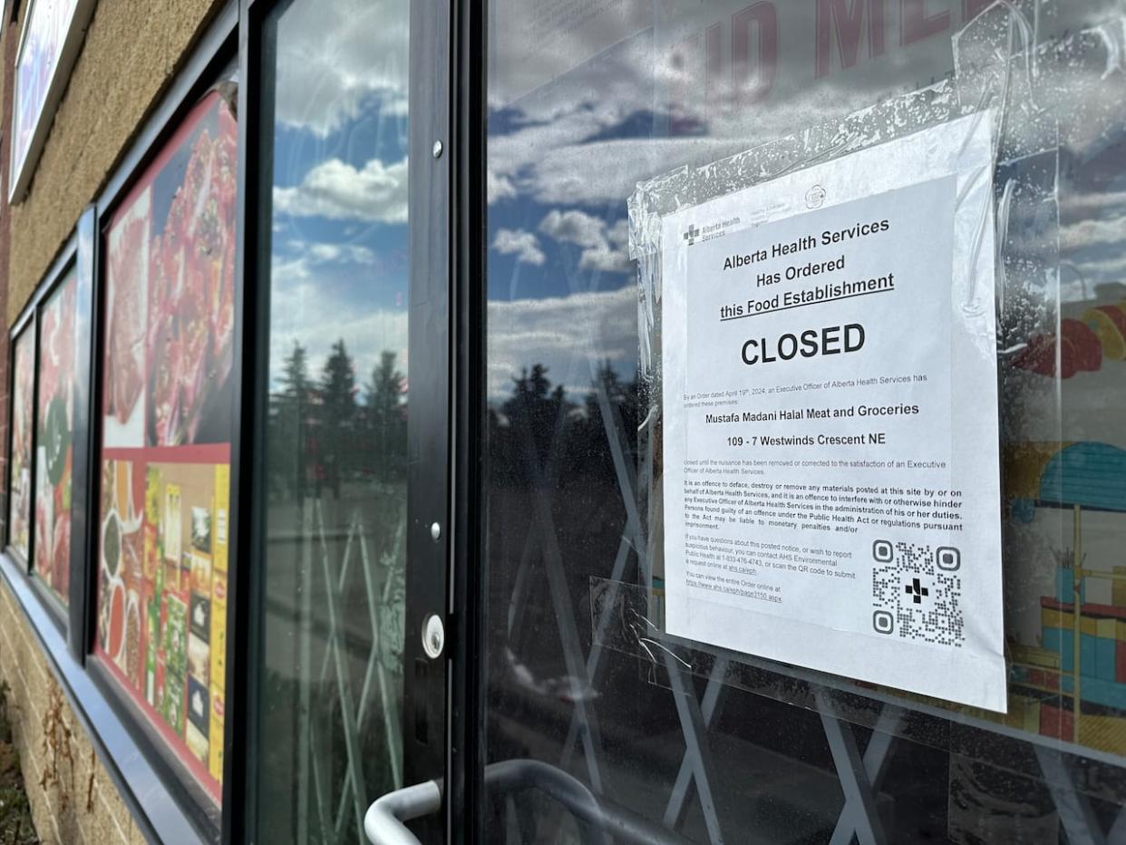 A closure order on the door of Mustafa Madani Halal Meat and Groceries in Calgary. It is one of five halal food establishments closed by Alberta Health Services on Friday. (James Young CBC News - image credit)