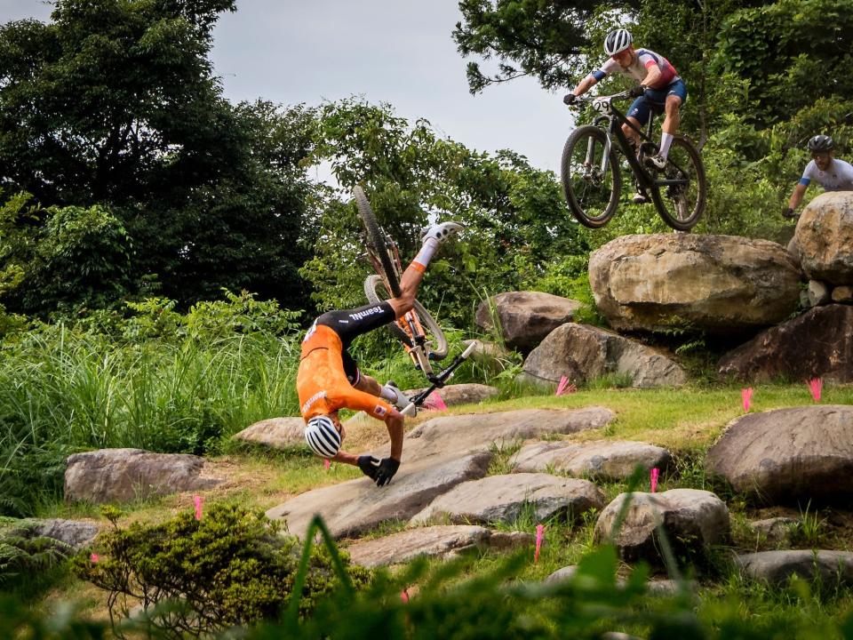 Mathieu Van der Poel falls off his bike over some rocks at the Tokyo Olympics.