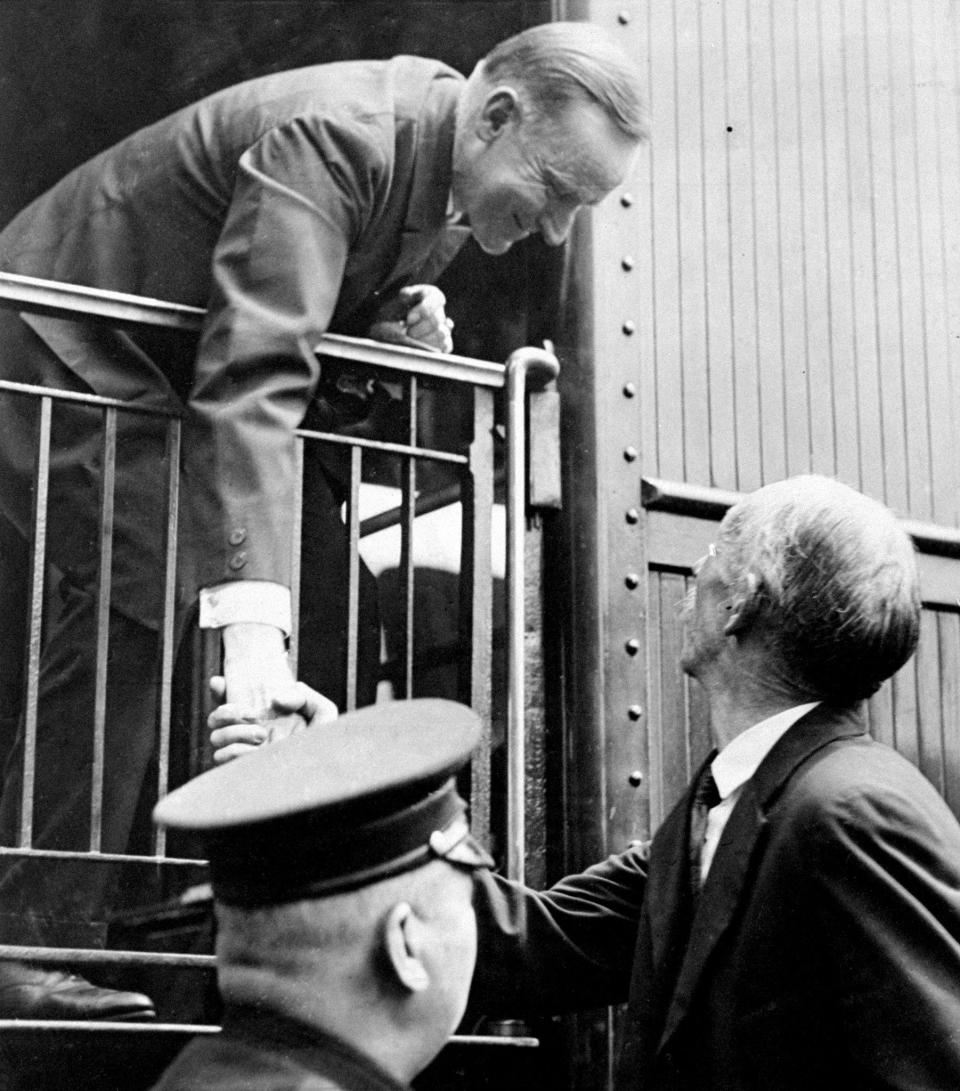 President Calvin Coolidge shakes hand with one of his supporters as he boards a train for New York City in February 1924