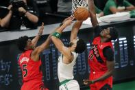 Toronto Raptors' Stanley Johnson (5) and Pascal Siakam (43) block a shot by Boston Celtics' Jayson Tatum during the first half of an NBA basketball game, Thursday, Feb. 11, 2021, in Boston. (AP Photo/Michael Dwyer)