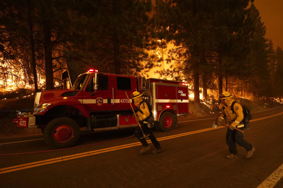 Firefighters run along state Highway 168 while fighting the Creek Fire, Sunday, Sept. 6, 2020, in Shaver Lake, Calif. (AP Photo/Marcio Jose Sanchez)