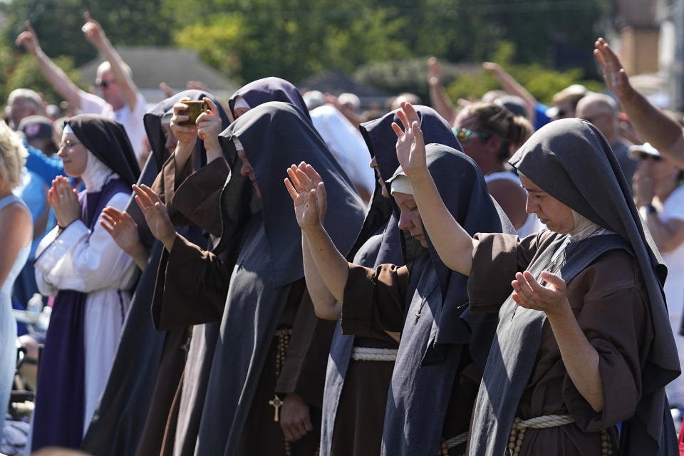 Attendees pray during a "rosary rally" on Sunday, Aug. 6, 2023, in Norwood, Ohio. A national religious organization, Catholics for Catholics, gathered a lineup of anti-abortion influencers and conspiracy theorists from across the U.S. to speak at the rally to urge a “yes” vote on a ballot question in Ohio, known as Issue 1. If voters approve Issue 1, it would make it more difficult for an abortion rights amendment on the November ballot to succeed. (AP Photo/Darron Cummings)