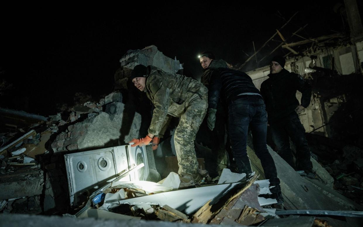 Rescuers remove debris to search for survivors at a destroyed apartment building hit by a rocket during the night in downtown Kramatorsk - Getty