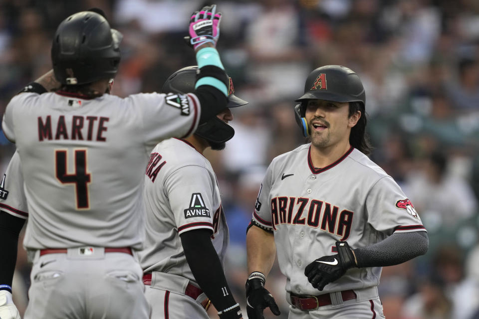 Arizona Diamondbacks' Corbin Carroll is greeted at home plate by Pavin Smith, Ketel Marte (4), and Jose Herrera after his grand slam during the seventh inning of a baseball game against the Detroit Tigers, Friday, June 9, 2023, in Detroit. (AP Photo/Carlos Osorio)