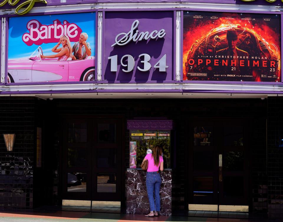 A patron buys a movie ticket underneath a marquee featuring the films "Barbie" and "Oppenheimer" at the Los Feliz Theatre, Friday, July 28, 2023, in Los Angeles. (AP Photo/Chris Pizzello) ORG XMIT: CACP101