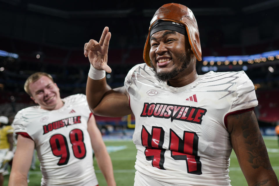 Louisville defensive lineman Selah Brown (44) poses with a replica Old Leather Helmet during the second half of an NCAA college football game, Friday, Sept. 1, 2023, in Atlanta. Louisville won 39-34. (AP Photo/Mike Stewart)