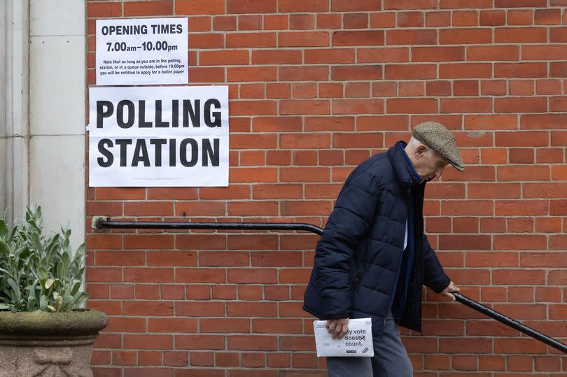 An elderly man exits a polling station in London