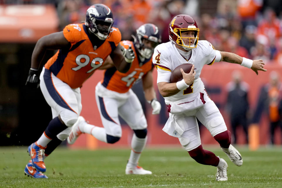 Washington Football Team quarterback Taylor Heinicke (4) scrambles as Denver Broncos defensive tackle Shamar Stephen (99) pursues during the first half of an NFL football game, Sunday, Oct. 31, 2021, in Denver. (AP Photo/David Zalubowski)