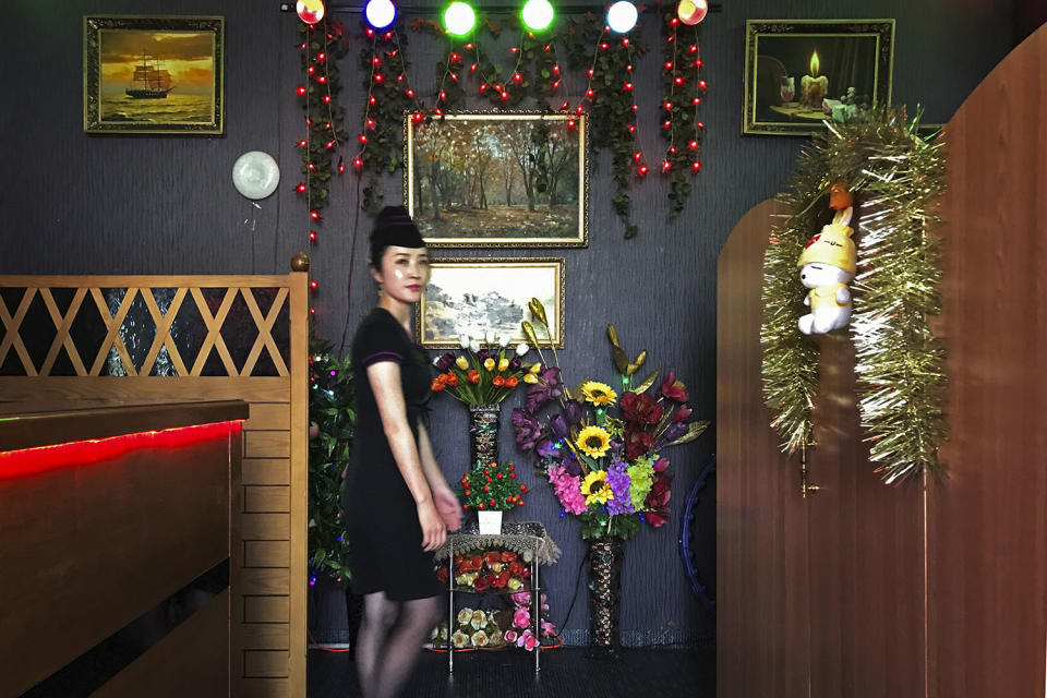 <p>A waitress walks past the decorated interiors of a “soft drink shop” located at the Kim Il Sung Square in Pyongyang, North Korea on June 18, 2017. (Photo: Wong Maye-E/AP) </p>