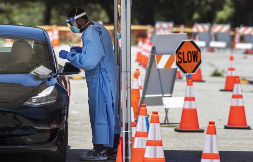 ENCINO, CA - JULY 23: EMT Travis Carr administers COVID-19 tests at Balboa Sports Center on Thursday, July 23, 2020 in Encino, CA. (Brian van der Brug / Los Angeles Times)