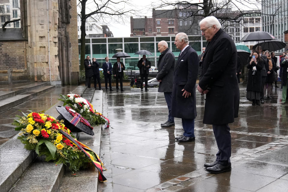 Britain's King Charles III, center, and German President Frank-Walter Steinmeier, right, lay a wreath of flowers at St. Nikolai Memorial in Hamburg, Germany, Friday, March 31, 2023. King Charles III arrived Wednesday for a three-day official visit to Germany. (AP Photo/Matthias Schrader)
