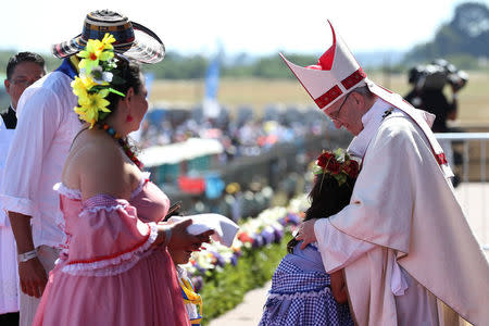 A girl hugs Pope Francis as he is greeted by a family during a mass at the Maquehue Temuco Air Force base, Chile, January 17, 2018. REUTERS/Alessandro Bianchi