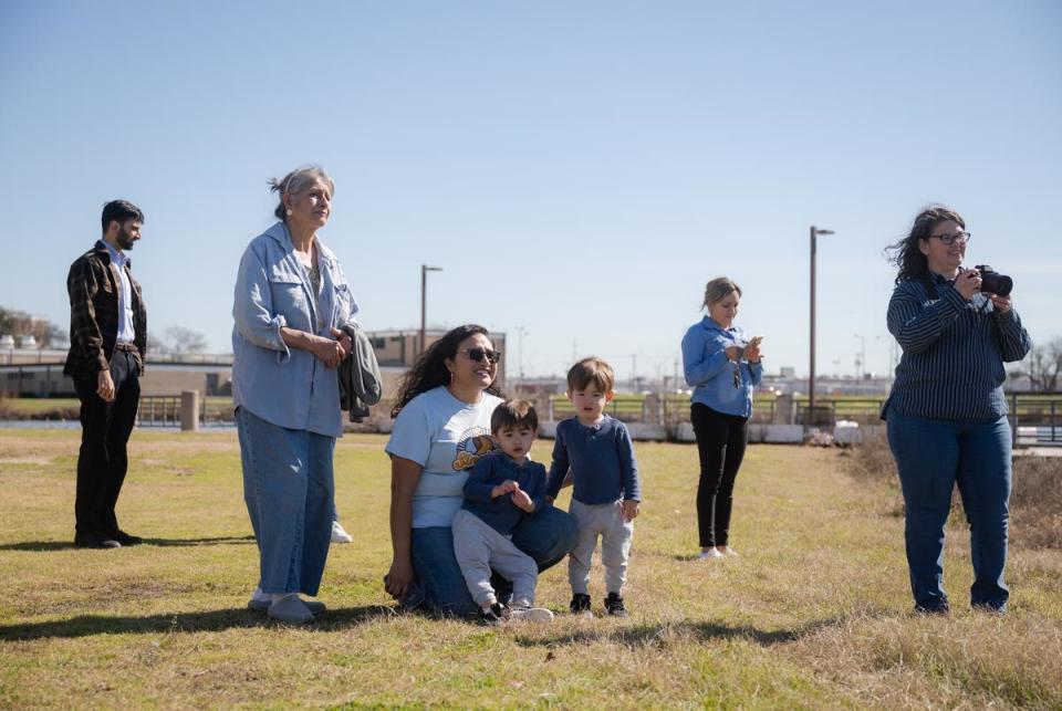 DALLAS, TX - JANUARY 30, 2024: Janie Cisneros, 41, director of Singleton United/ UNIDOS, (third from left) watches as employees of the U.S. Environmental Protection Agency (EPA) retrieve gillnets previously set out at Fish Trap Lake Park in Dallas, Texas on Tuesday, Jan. 30, 2024. The city of Dallas and local community leaders partnered with the EPA on the Cumulative Impacts Assessment Pilots Project, which focuses on the cumulative impacts from concrete batch plants. CREDIT: Desiree Rios for The Texas Tribune