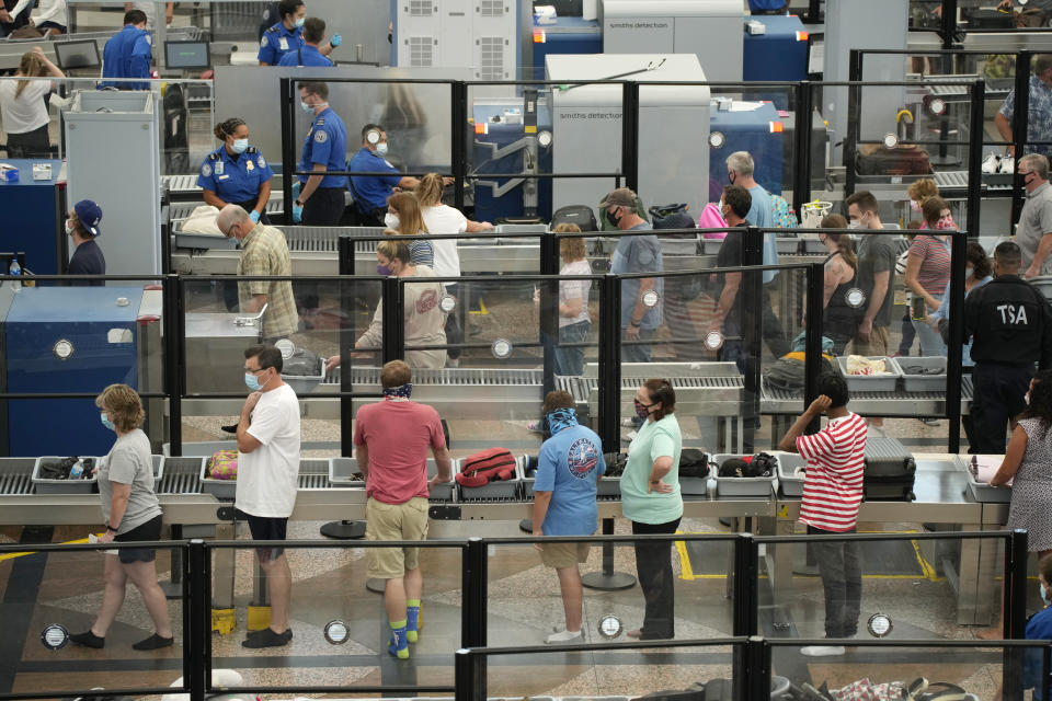 Travelers wear face coverings in the queue for the north security checkpoint in the main terminal of Denver International Airport Tuesday, Aug. 24, 2021, in Denver. Two months after the Sept. 11, 2001 attacks, President George W. Bush signed legislation creating the Transportation Security Administration, a force of federal airport screeners that replaced the private companies that airlines were hiring to handle security. (AP Photo/David Zalubowski)