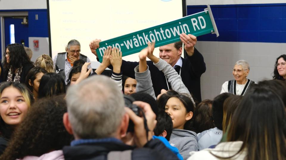 Saskatoon Mayor Charlie Clark holds one of the new miyo-wâhkôhtowin Road signs that were installed on Thursday, Dec. 7, 2023.