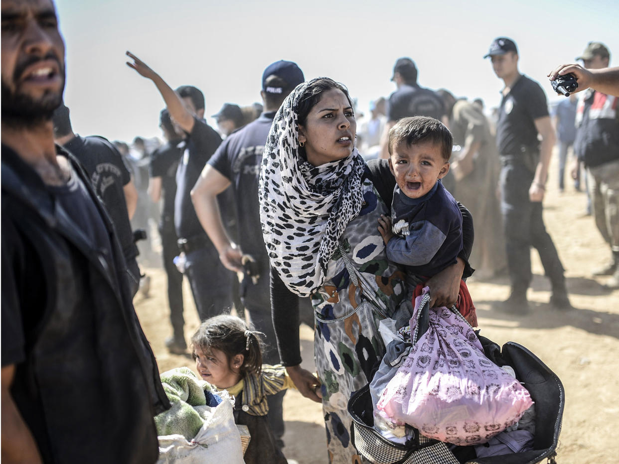 A Syrian Kurdish woman crosses the border between Syria and Turkey at the southeastern town of Suruc in Sanliurfa province on 23 September, 2014: BULENT KILIC/AFP/Getty Images