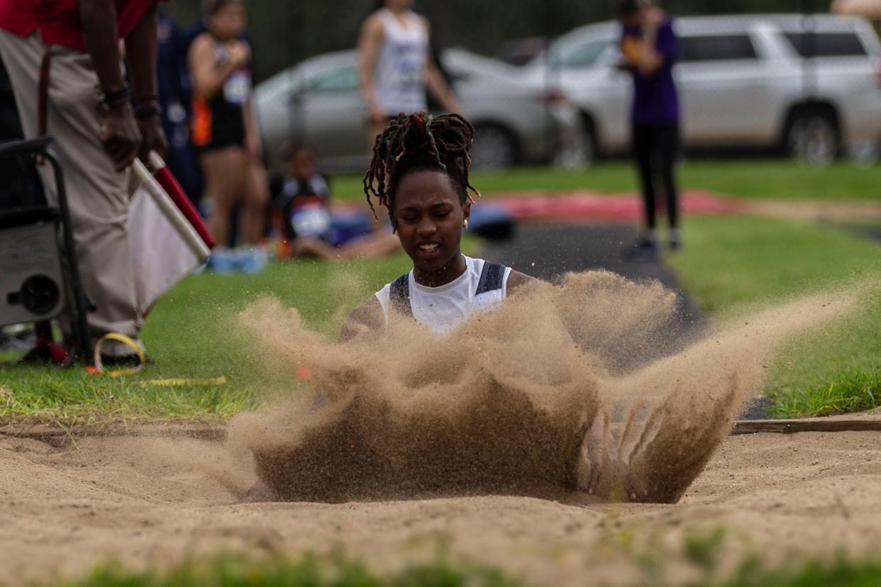 Guilford jumper Zariah Burnett kicks up sand after jumping during a NIC-10 track and field meet on Thursday, May 2, 2024, at Guilford High School.