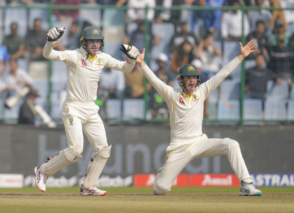 Australian wicketkeeper Alex Carey, left, and Peter Handscomb successfully appeals for LBW against India's Cheteshwar Pujara during the second day of the second cricket test match between India and Australia in New Delhi, India, Saturday, Feb. 18, 2023. (AP Photo/Altaf Qadri)