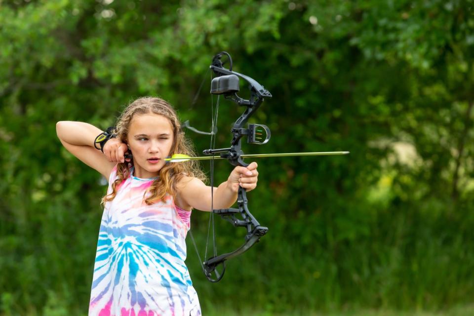 Someone is outdoors, about to shoot an arrow.