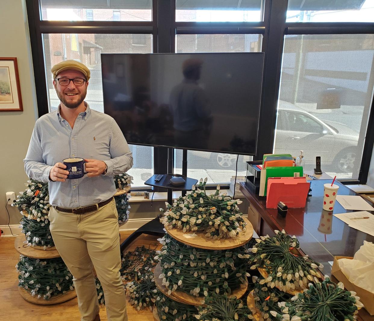 Uptown Lexington Executive Director Jacob Gordon stands in his office on East First Avenue with several strands of Christmas lights that will soon be strung on the trees along Main Street in Lexington. All the Uptown Lexington-sponsored holidays events are back this year with the addition of a new event.