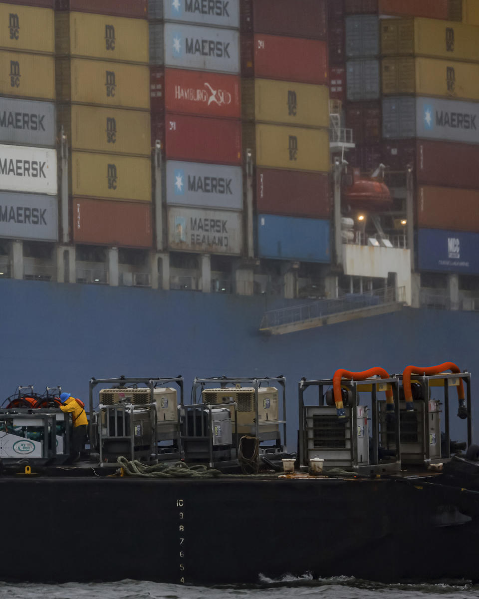 Cranes continue salvage work as wreckage of the Francis Scott Key Bridge rests on the container ship Dali, Wednesday, April 3, 2024, in Baltimore. (AP Photo/Julia Nikhinson)