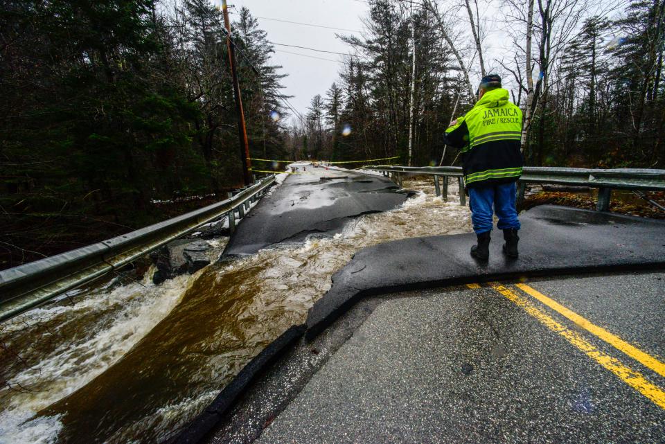 Members of the Jamaica, Vt., Fire Department look at the damage to a failed culvert for the North Branch Ball Mountain Brook on Monday (AP)