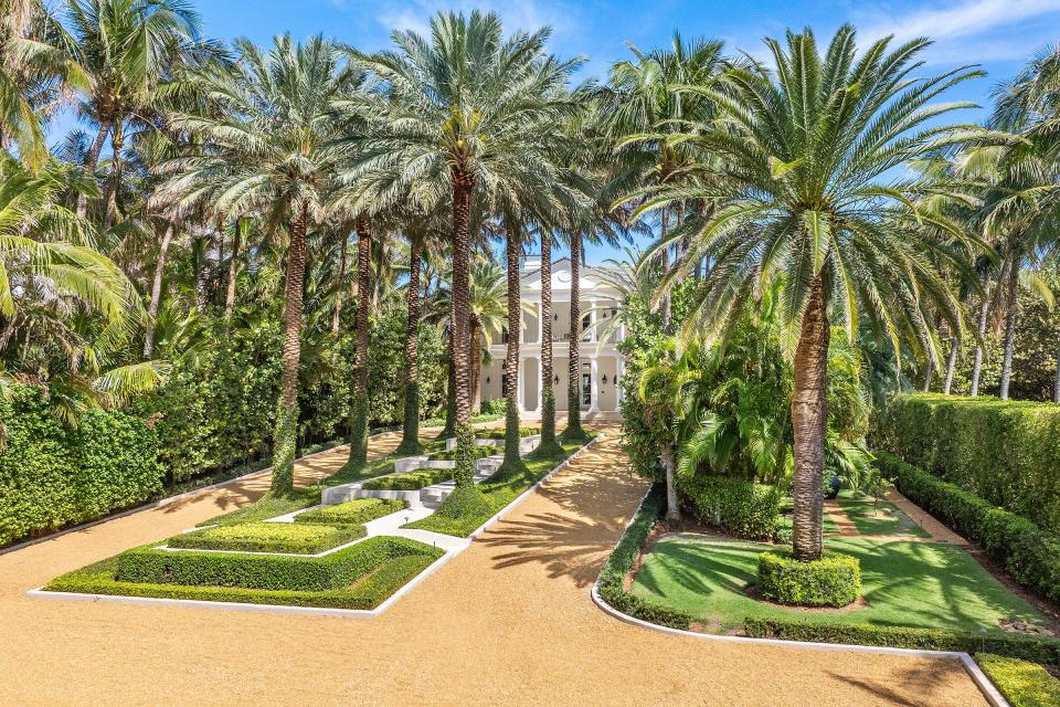 An allée of palms borders terraced steps that lead to the front of a house just listed for $78.5 million at 2315 S. Ocean Blvd. in Palm Beach.