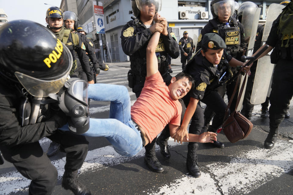 An anti-government protesters who traveled to the capital from across the country to march against Peruvian President Dina Boluarte, is detained by the police during clashes in Lima, Peru, Thursday, Jan. 19, 2023. Protesters are seeking immediate elections, Boluarte's resignation, the release of ousted President Pedro Castillo and justice for up to 48 protesters killed in clashes with police. (AP Photo/Martin Mejia)