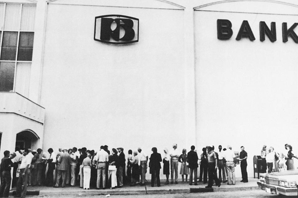 File - Hundreds of customers of the insolvent Penn Square Bank line up to withdraw their money, on Tuesday July 6, 1982, in Oklahoma City after federal officials closed the bank. The recent failure of Silicon Valley Bank was unlike a traditional bank run. It involved Twitter, internet memes and message boards and happened at unprecedented speed. (AP Photo, File)