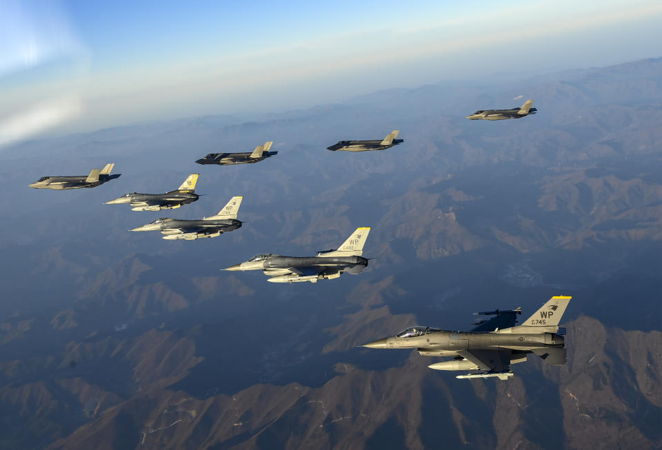 In this photo provided by South Korean Defense Ministry, four South Korean Air Force F-35 fighter jets, left top, and four US Air Force F-16 fighter jets fly over South Korea during a joint air drill in South Korea, Friday, Nov. 18, 2022. North Korea fired an intercontinental ballistic missile that landed near Japanese waters Friday in its second major weapons test this month that showed a potential ability to launch nuclear strikes on all of the U.S. mainland. (South Korean Defense Ministry via AP)