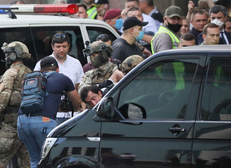 Members of a Ukrainian special forces unit detain a man who threatened to blow up a bomb in a bank branch, in Kyiv