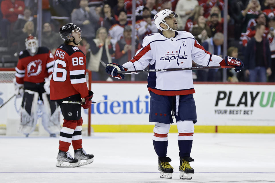 Washington Capitals left wing Alex Ovechkin watches a replay of a goal scored by New Jersey Devils center Jack Hughes (86) during the second period of an NHL hockey game Saturday, Nov. 26, 2022, in Newark, N.J. (AP Photo/Adam Hunger)