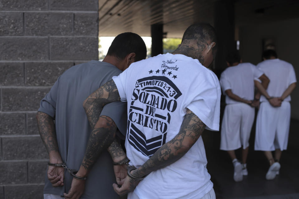 Supuestos pandilleros caminan esposados hacia un juicio en el centro Isidro Menéndez en San Salvador, El Salvador, el jueves 10 de octubre de 2019. (AP Foto/Salvador Melendez)