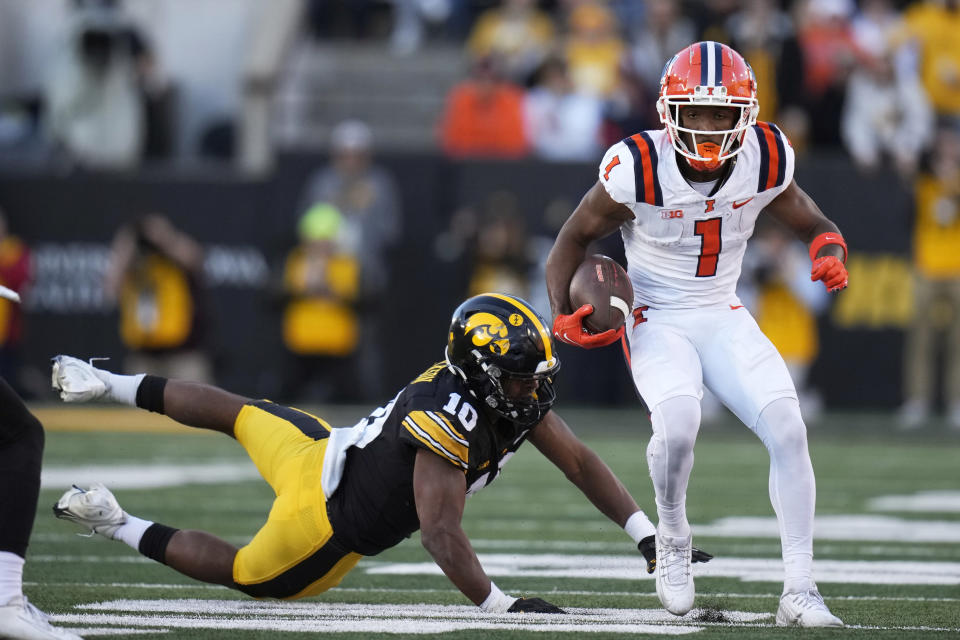 Illinois wide receiver Isaiah Williams (1) runs from Iowa linebacker Nick Jackson (10) after catching a pass during the first half of an NCAA college football game, Saturday, Nov. 18, 2023, in Iowa City, Iowa. (AP Photo/Charlie Neibergall)