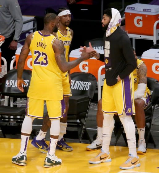 Lakers forward LeBron James exchanges a handshake with teammate Anthony Davis after a season-ending loss June 3, 2021.