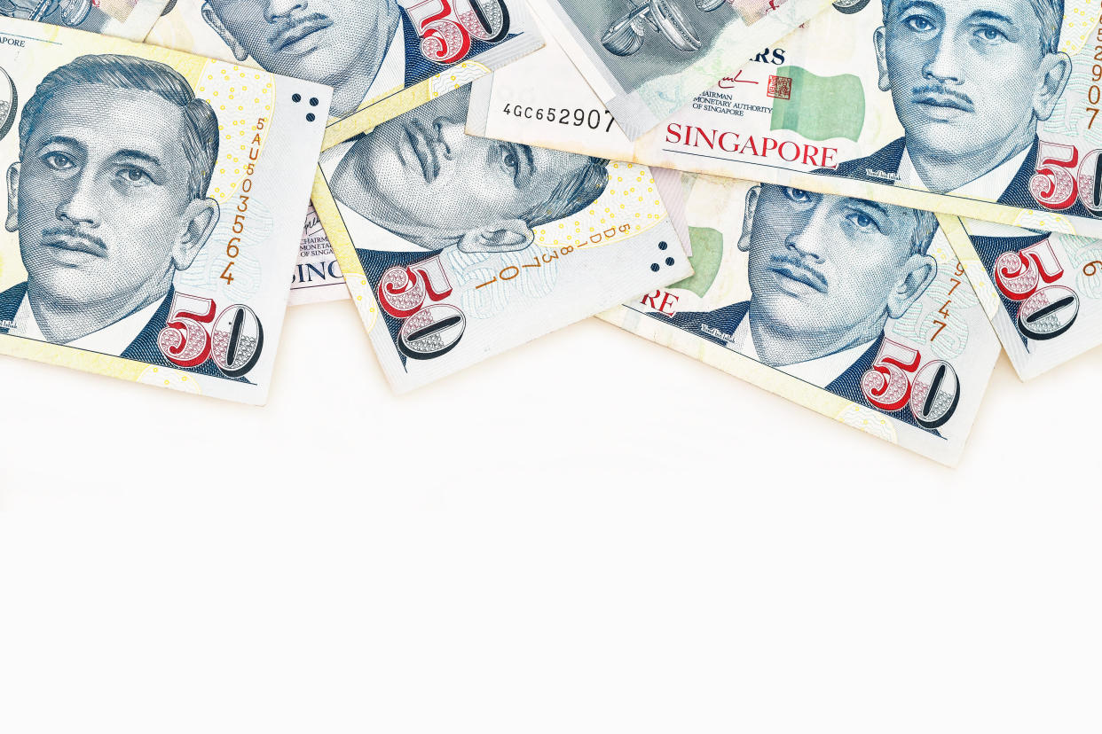 Singapore fifty dollar notes on white background, illustrating a story on T-bills.