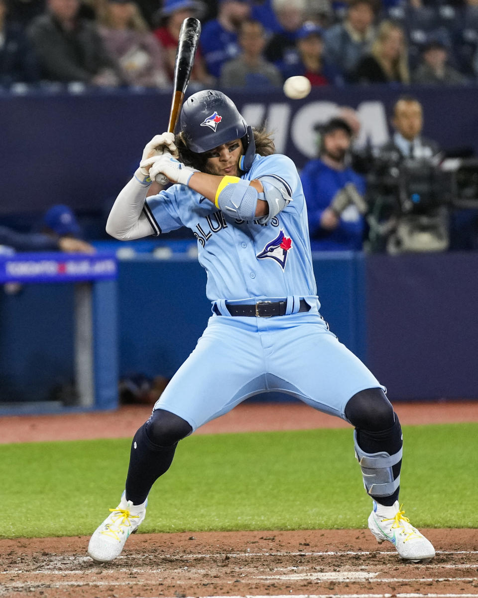 Toronto Blue Jays shortstop Bo Bichette (11) tries to move out of the way of a wide pitch during the fifth inning of a baseball game against the Chicago White Sox in Toronto, Wednesday, April 26, 2023. (Andrew Lahodynskyj/The Canadian Press via AP)