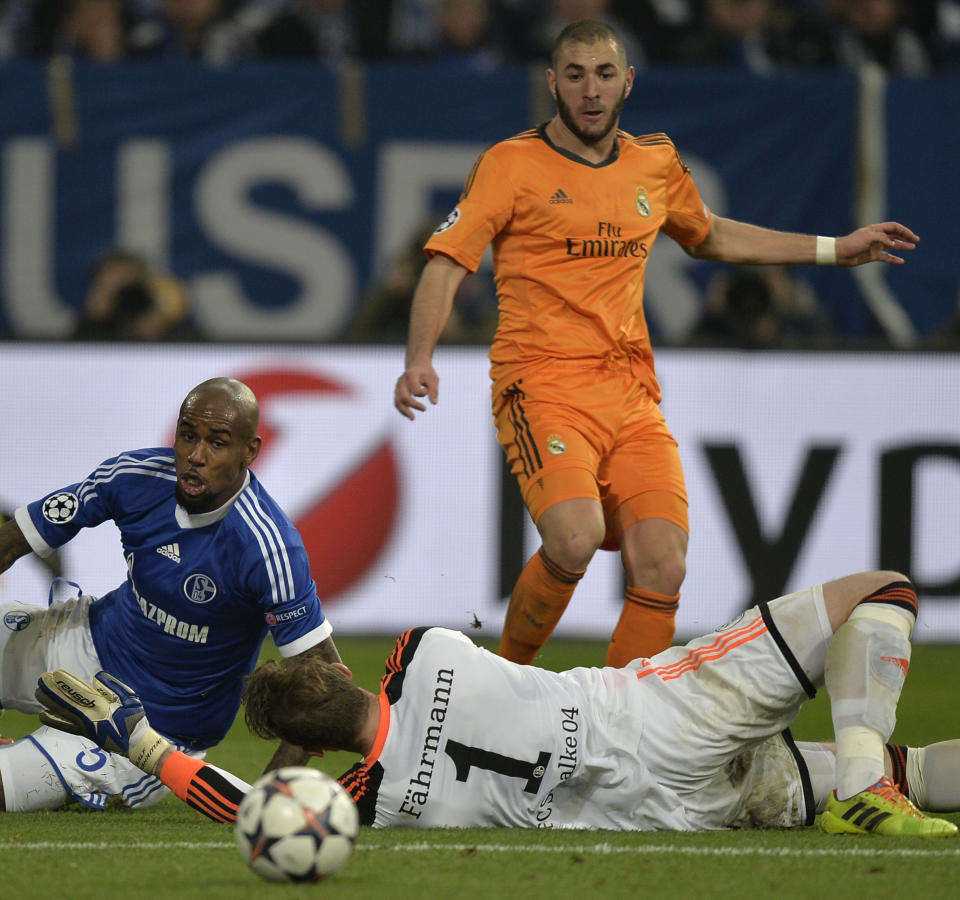 Real's Karim Benzema, top scores past Schalke goalkeeper Ralf Faehrmann during a Champions League round of sixteen, first leg soccer match between Schalke 04 and Real Madrid at the Veltins Arena in Gelsenkirchen, Germany, Wednesday Feb. 26, 2014. (AP Photo/Martin Meissner)