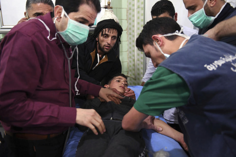 In this photo released by the Syrian official news agency SANA, shows medical staff treating a boy following a suspected chemical attack on his town of al-Khalidiya, in Aleppo, Syria, Saturday, Nov. 24, 2018. Some 50 civilians were being treated following a suspected poison gas attack by Syrian rebel groups on the government-held Aleppo city in the country's north, according to Syrian state media. (SANA via AP)