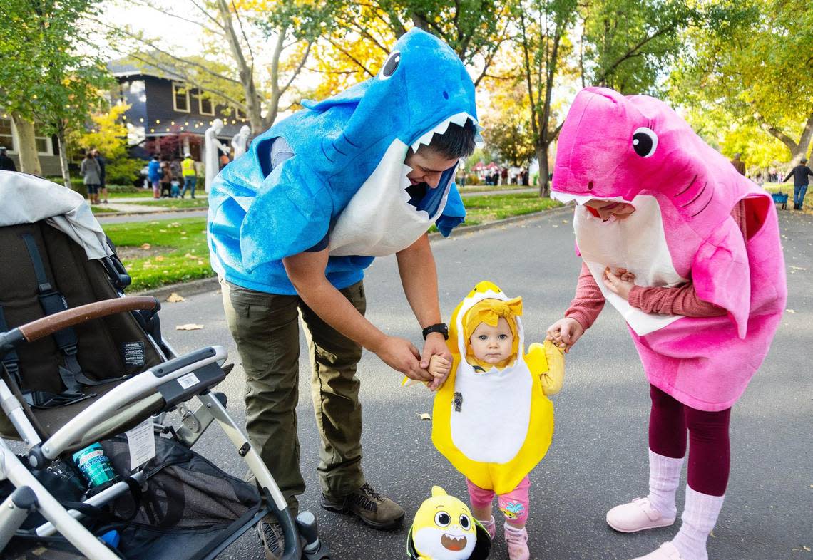 Conner and Cearston Oberst trick-or-treat as a shark family with their daughter Averleigh on Harrison Boulevard in Boise during Halloween on Oct 31, 2022.