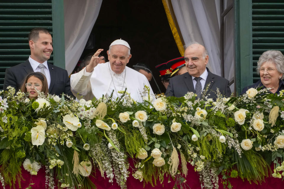 Pope Francis, center, with, from left, Malta Prime Minister Robert Abela, his daughter Giorgia Mae, Malta's President George William Vella and his wife Miriam, waves to a cheering crowd from a balcony of the Grand Master's Palace in Valletta, Malta, Saturday, April 2, 2022. Pope Francis headed to the Mediterranean island nation of Malta on Saturday for a pandemic-delayed weekend visit, aiming to draw attention to Europe's migration challenge that has only become more stark with Russia's invasion of Ukraine. (AP Photo/Andrew Medichini)