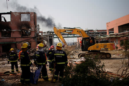 Firefighters work on the site as smoke rises behind following an explosion at a pesticide plant owned by Tianjiayi Chemical, in Xiangshui county, Yancheng, Jiangsu province, China March 23, 2019. REUTERS/Aly Song