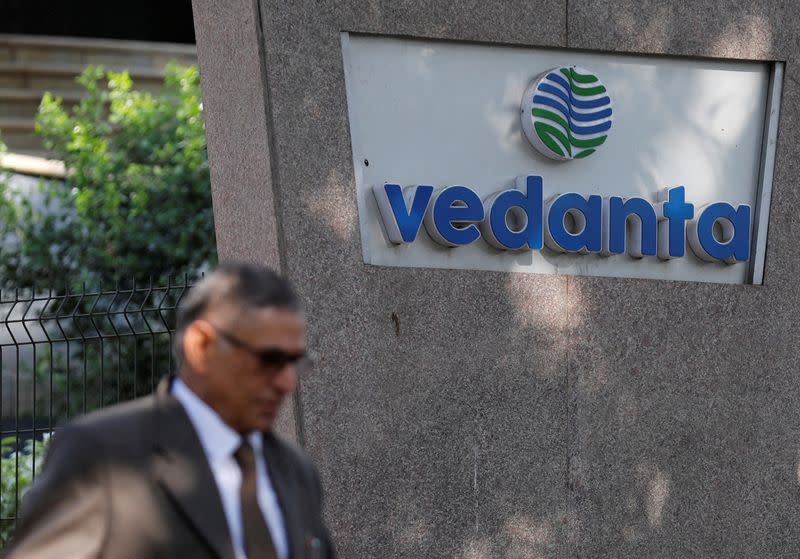 FILE PHOTO: FILE PHOTO: A man walks past the logo of Vedanta outside its headquarters in Mumbai