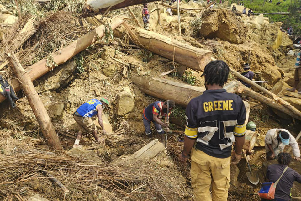 In this image supplied by the International Organization for Migration, villagers search amongst the debris from a landslide in the village of Yambali in the Highlands of Papua New Guinea, Monday, May 27, 2024. (Mohamud Omer/International Organization for Migration via AP)