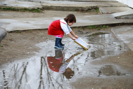 A girl plays at the paddle inside the camp for refugees and migrants in the Belgrade suburb of Krnjaca, Serbia, January 16, 2018. Picture taken January 16, 2018 REUTERS/Djordje Kojadinovic