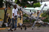 <p>A man feeds pigeons next to a fallen power pole in the aftermath of Hurricane Irma in Puerto Plata, Dominican Republic, Sept. 8, 2017. (Photo: Ivan Alvarado/Reuters) </p>