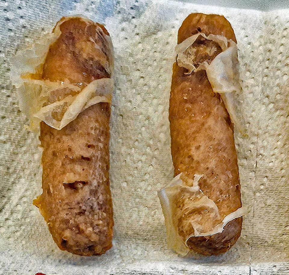 two sausage links covered in bits of paper towel