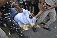 A supporter of opposition Congress party is detained by police while protesting against their leader Rahul Gandhi's expulsion from Parliament in New Delhi, India, Monday, March 27, 2023. Gandhi was expelled from Parliament a day after a court convicted him of defamation and sentenced him to two years in prison for mocking the surname Modi in an election speech. (AP Photo/Deepanshu Aggarwal)