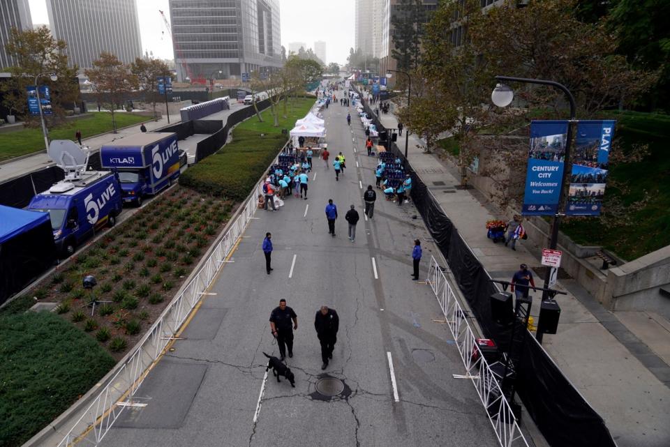 Police officers with a K-9 inspect the finish line route of the Los Angeles Marathon in November 2021.